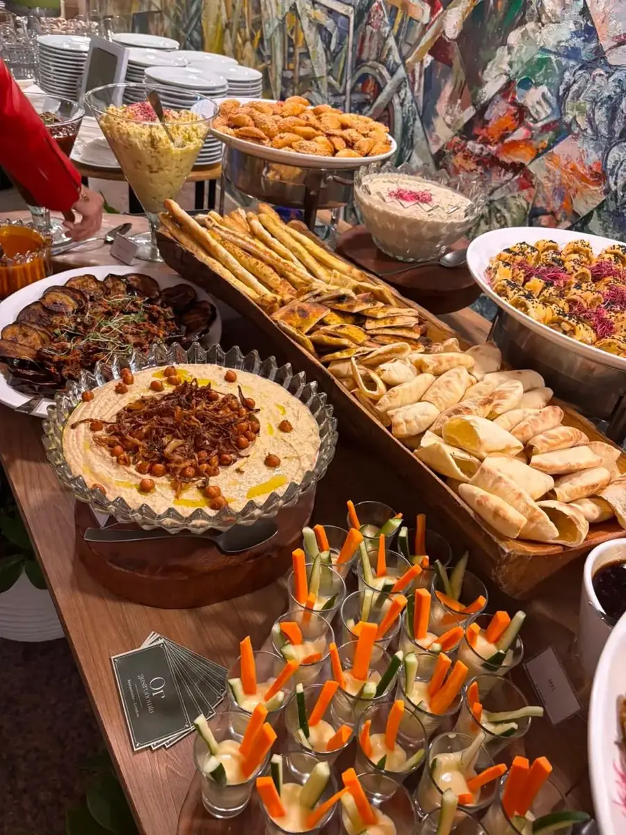 Buffet de entradas com homus, saladas, pitas, salgados e espetinhos de legumes