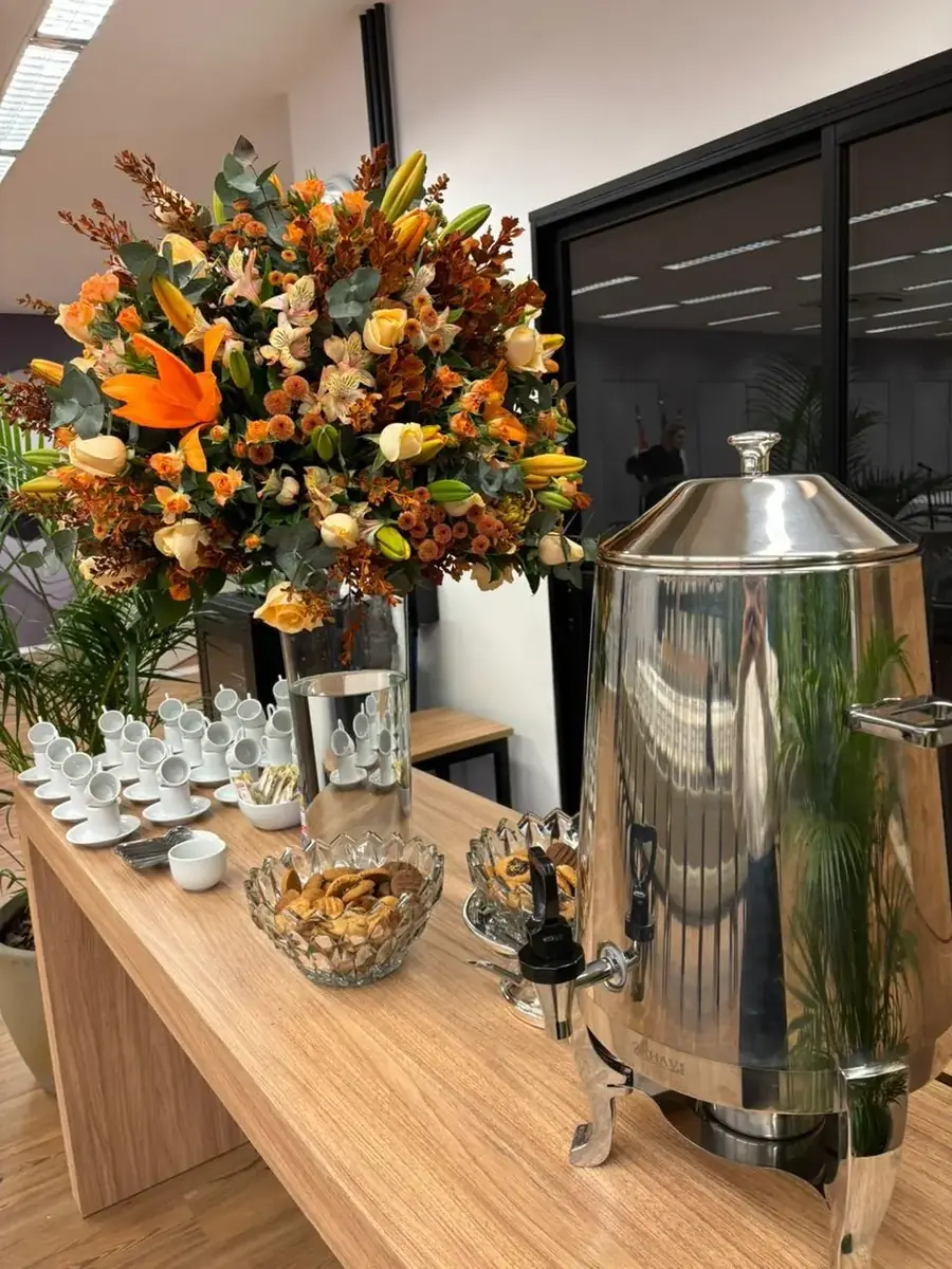 Estação de café com samovar, xícaras e arranjo de flores