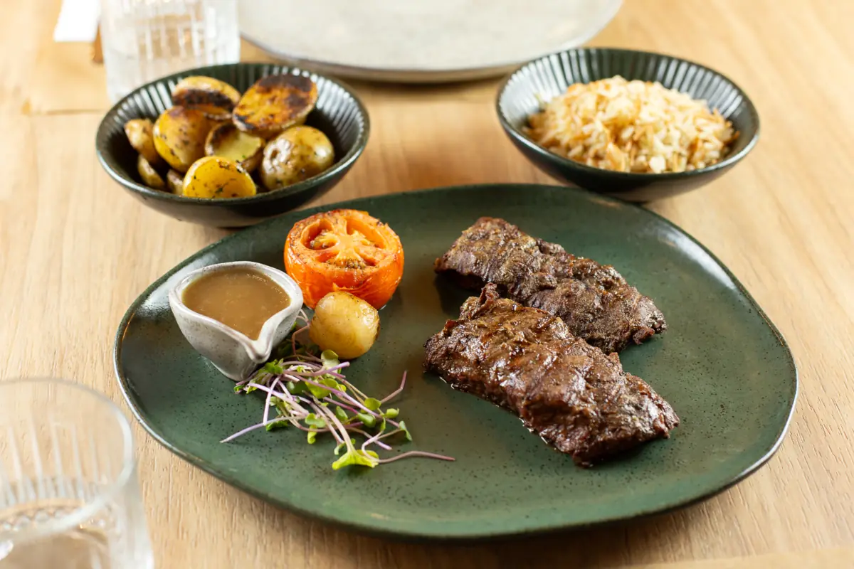 Flat iron grelhado com tomate assado, batata bola e arroz cabelo de anjo