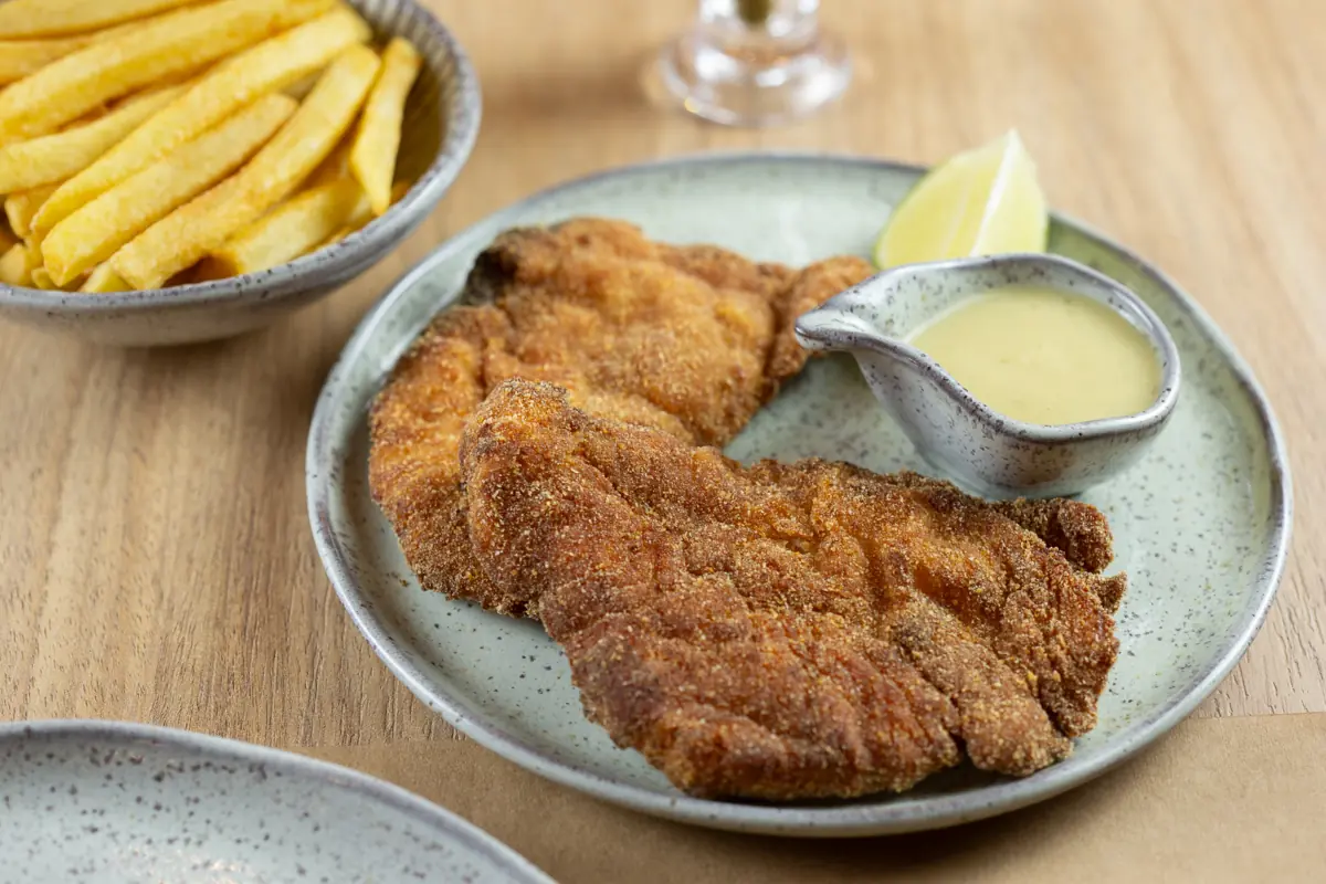 Shenitzel de frango empanado com batata frita e molho dijon