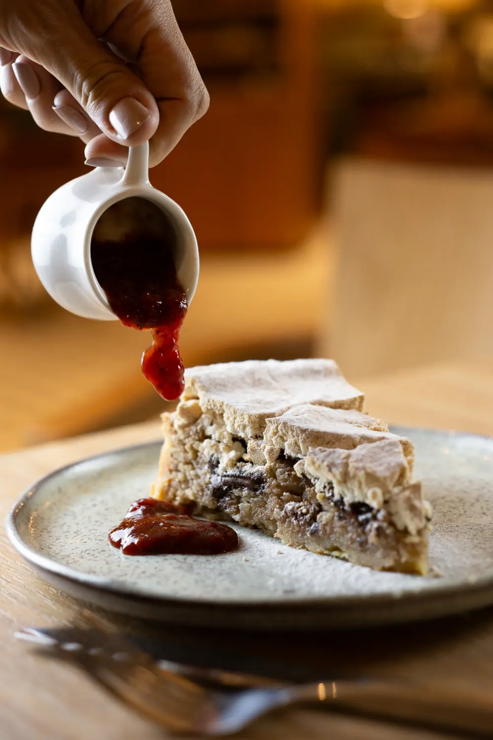 Fatia de torta de suspiro queimado com calda de frutas vermelhas